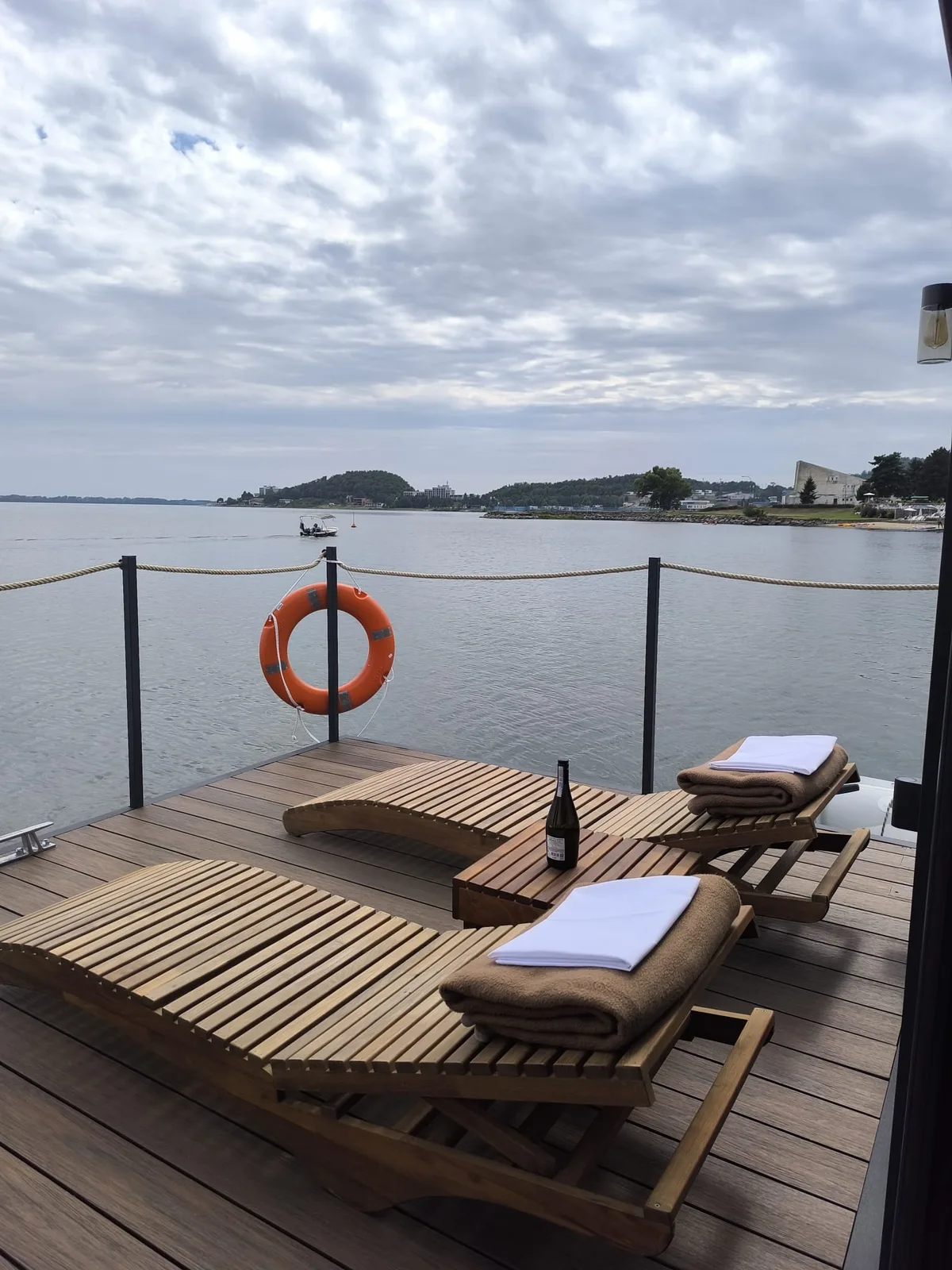 Drevená terasa houseboatu s ležadlami a výhľadom na hladinu Zemplínskej šíravy.