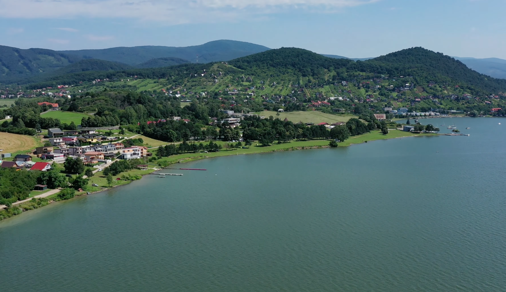 Letecký pohľad na stredisko Kamenec pri Šírave s dedinou, plážami a zelenými kopcami Vihorlatu